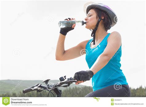 Athletic Woman On Mountain Bike Drinking Water Stock Image