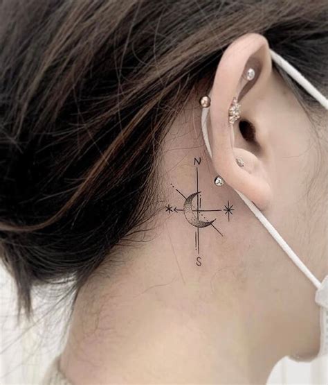 A Womans Behind The Ear Has A Compass Tattoo On Her Left Side