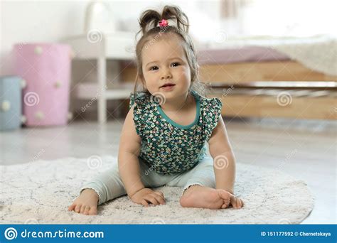 Adorable Little Baby Girl Sitting On Floor Stock Photo