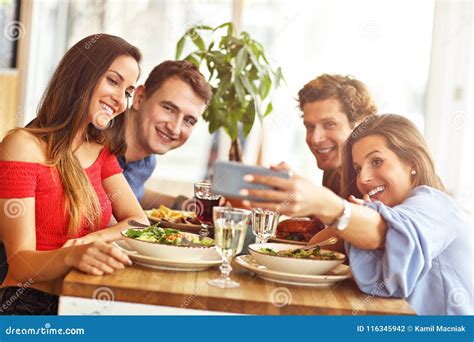 Group Of Friends Enjoying Meal In Restaurant Stock Photo Image Of