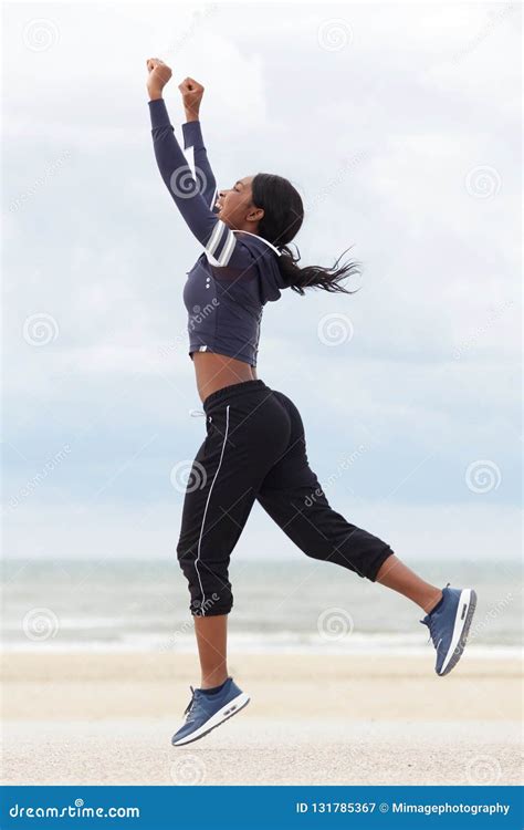 Full Body African American Woman Running And Jumping With Arms Raised