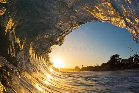 A Single Ocean Wave Tube At Sunset On The Beach Stock Photo Image