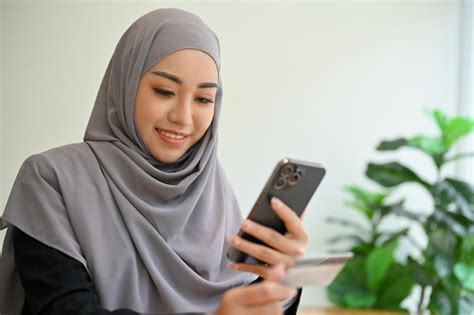 Premium Photo Attractive Young Asian Muslim Woman With Hijab Using A Smartphone Chatting With