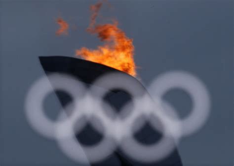 The Olympic Flame Is Reflected In A Window At The Olympics Park During