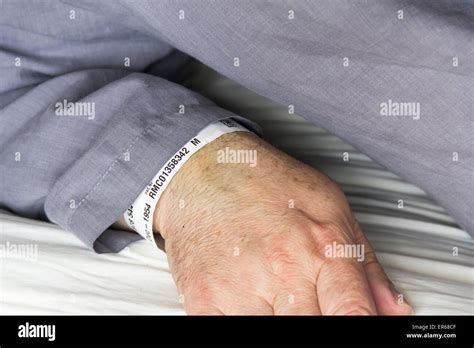 Close Up Of The Arm Of A Middle Aged Man In Grey Pyjamas In Bed With A