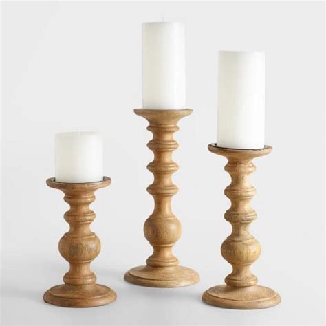 Three Candles Are Sitting Next To Each Other On A White Tablecloth With