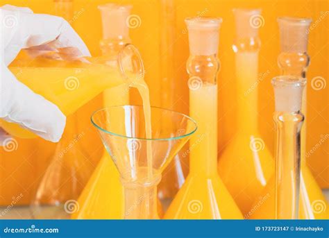 Closeup A Long Row Of Glass Flasks With A Yellow Solution On A