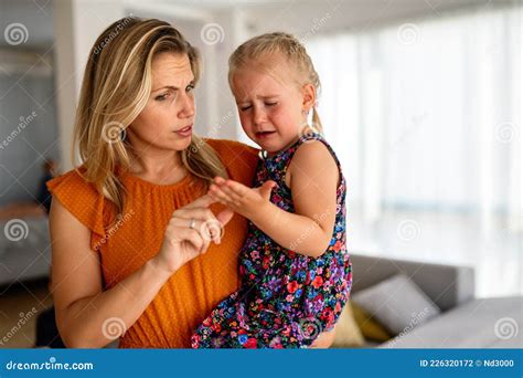 Mother Comforting Her Crying Child After She Hit Her Hand Stock Photo
