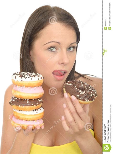 Attractive Natural Happy Young Woman Holding A Pile Of Iced Donuts