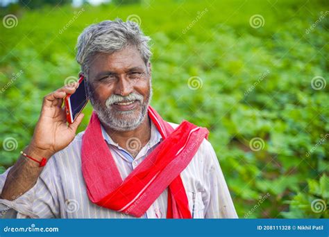 Indian Farmer Talking On Mobile Phone At Agriculture Field Stock Photo