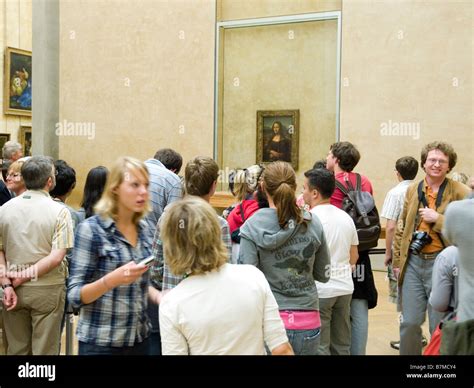 Visitors To The Louvre Museum Looking At The Mona Lisa Painted By