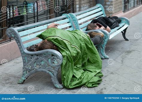 Homeless Person Is Sleeping On A Bench In A Cold Autumn Day In A Park
