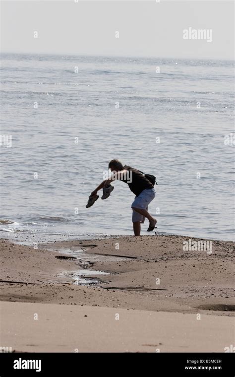 Man Falling Over With Feet Trapped In The Sand On The Beach With Shoes