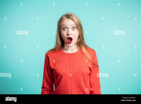 Surprised Young Woman Shouting On Blue Background Looking At Camera