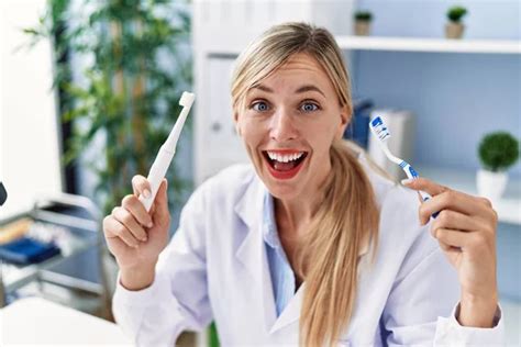 Beautiful Dentist Woman Holding Ordinary Toothbrush And Electric