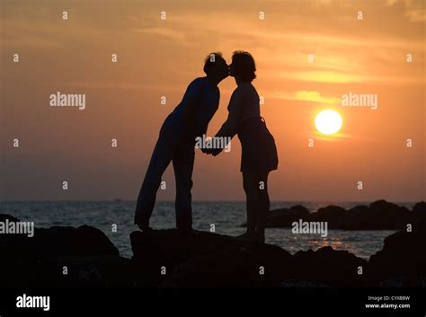 A Couple By Sunset On A Pier Kissing Each Other Stock Photo Alamy