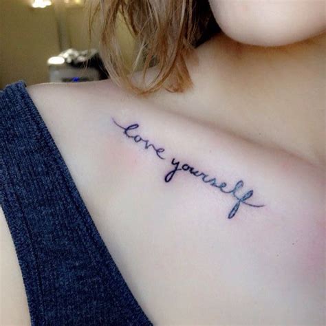a woman s chest with the words love yourself tattooed on her left side shoulder
