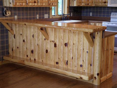 The kitchen island with breakfast bar is an all wood kitchen island with a two door cabinet and four drawers. Log Home Accessories | WoodHaven Log & Lumber