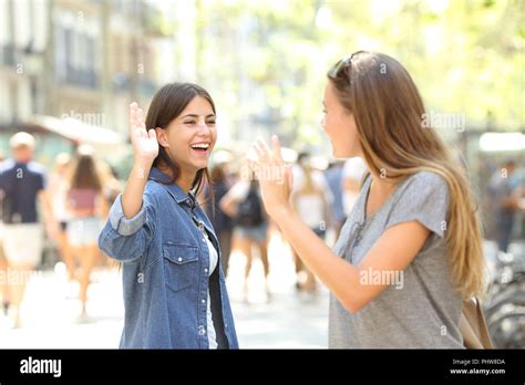 Two Happy Friends Meeting And Greeting In The Street Stock Photo Alamy
