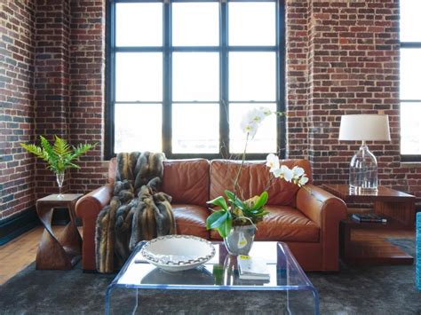 A Living Room With Brick Walls And Leather Furniture In The Center