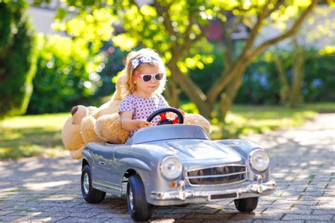 Little Adorable Toddler Girl Driving Big Vintage Toy Car And Having Fun