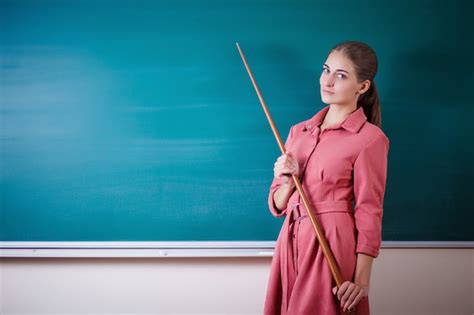 Premium Photo Young Woman Teacher Stands At A Blackboard With A