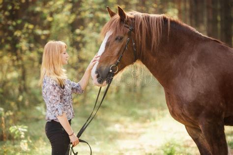 A Girl Stroking A Horse In An Autumn Forest Stock Photo Image Of