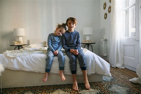 Portrait Of Brothers Wearing Pajama Resting On Bed By Stocksy
