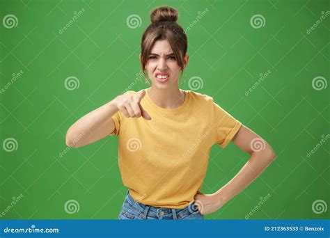 Portrait Of Arrogant Impolite Young Woman In Yellow T Shirt Pointing At