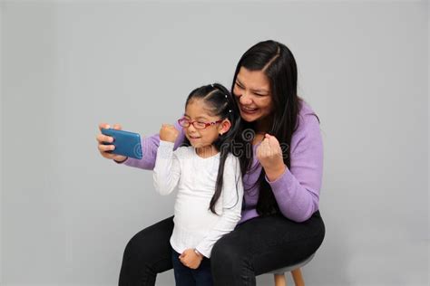 single divorced latina mom and daughter use cell phone to video call take selfies play video