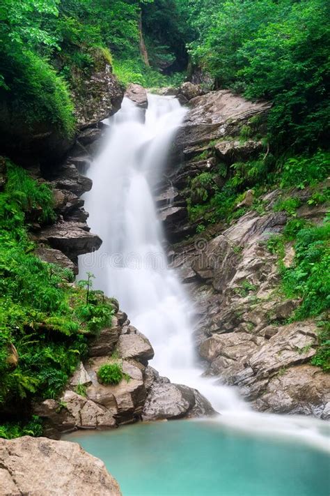 A Mountain Waterfall Flows Over The Rocks Deep Rainforest Waterfall