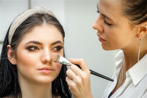 Premium Photo Closeup Portrait Of A Woman Applying Dry Cosmetic Tonal Foundation On The Face