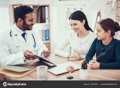 Indian Doctor Seeing Patients In Office Doctor Is Showing Clipboard To