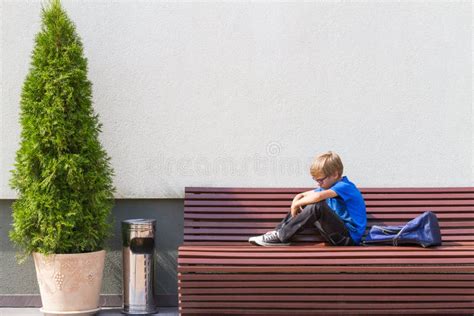 Sad Tired Child Sitting Alone On The Bench Outdoors Stock Image