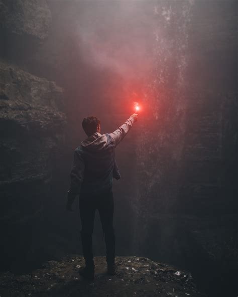 Man Lighting Up Flare In Cave Man Holding Red Light Standing Front Of