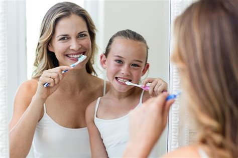 Premium Photo Mother And Daughter Brushing Their Teeth In The Bathroom