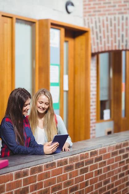 Premium Photo Smiling Students Using Tablet Together At University