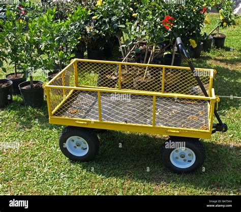 Yellow Four Wheel Cart With Handle That Is Used To Haul Plants And