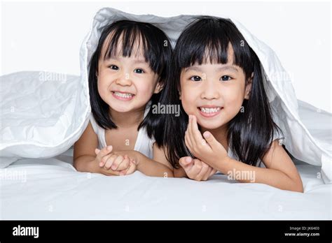 asian little chinese girls playing on the bed isolated on white