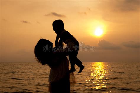 Madre E Hijo Que Juegan En La Playa En Tiempo Del Amanecer