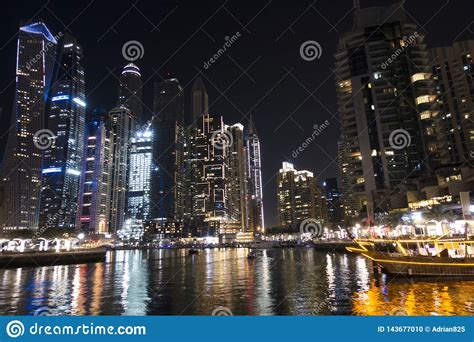 Illuminated Skyscrapers From Dubai Marina Reflected In Water During The