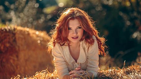 Redhead Girl Model Is Lying Down On Dry Grass Wearing White Dress In Blur Bokeh Background Hd