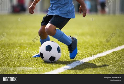 African American Young Boy Playing Soccer In A Stadium Pitch Child