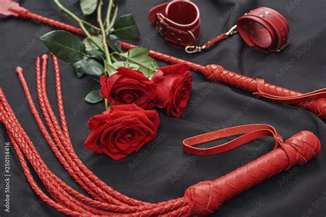 Playing Bdsm Games Top View Of Bdsm Leather Kit Handcuffs Whip And Roses Against Of Black