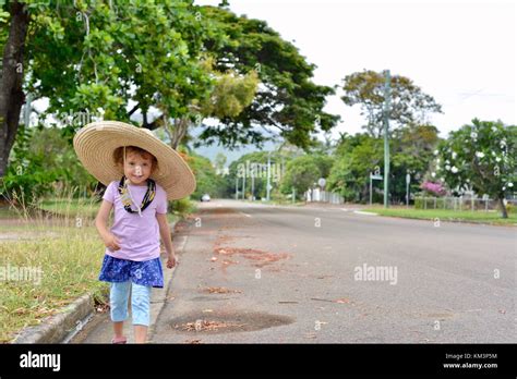 Young Girl Wearing A Sombrero Walking In A Suburban Street Townsville