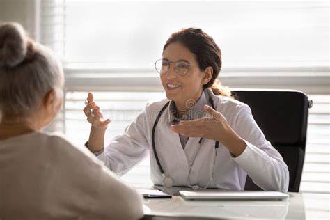Close Up Smiling Female Doctor Consulting Mature Woman Patient Stock