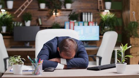 Businessman Sleeping With His Head On The Desk He Is Alone In The