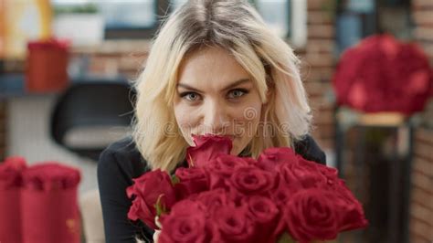 Portrait Of Seductive Woman In Love Smelling Red Rose And Looking At Camera Enjoying Valentine