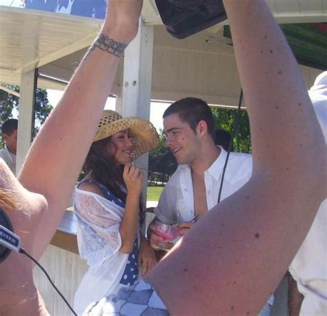 A Man And Woman Standing Next To Each Other In Front Of A Tent With