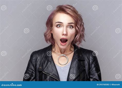 shocked amazed surprised woman standing looking at camera with big eyes and open mouth stock